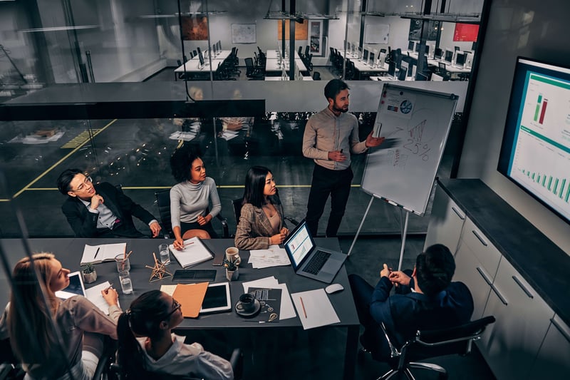 Man presenting data on CRM using a flip chart board