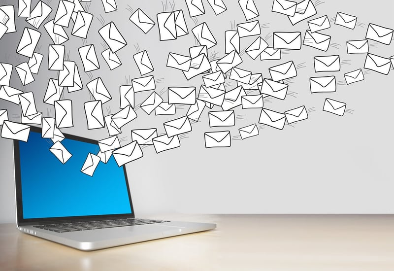 Laptop sending out a cloud of email messages